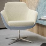 Moderner Loungesessel von Febrü (©) mit ergonomischer Form, zweifarbiger Polsterung und drehbarem Metallfuß in stilvollem Büroambiente.